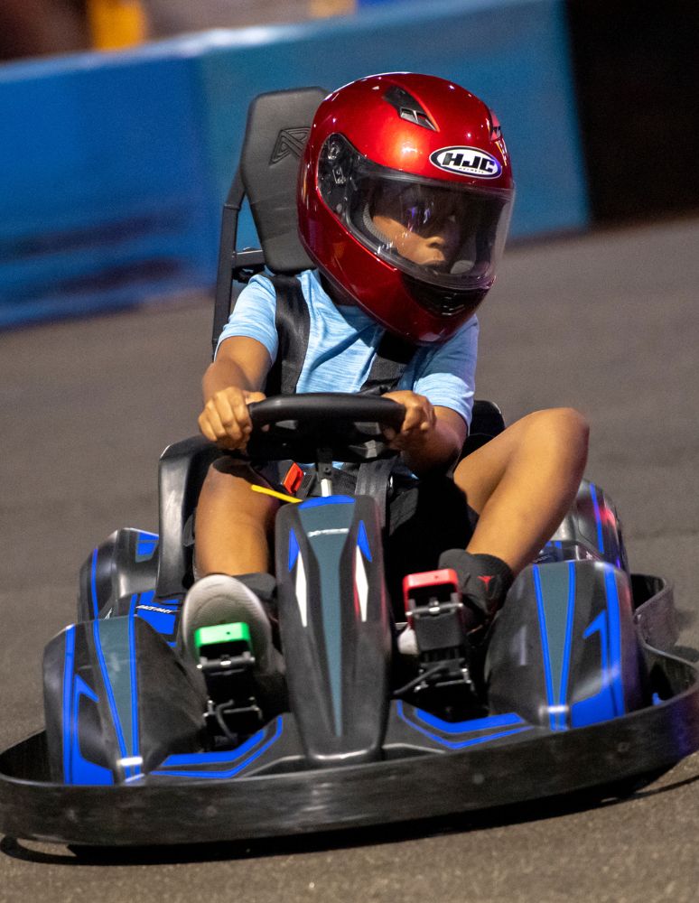 kid driving xlr 8 speedster go kart in an indoor go karting track